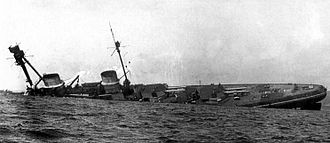 a large warship rolls onto its side